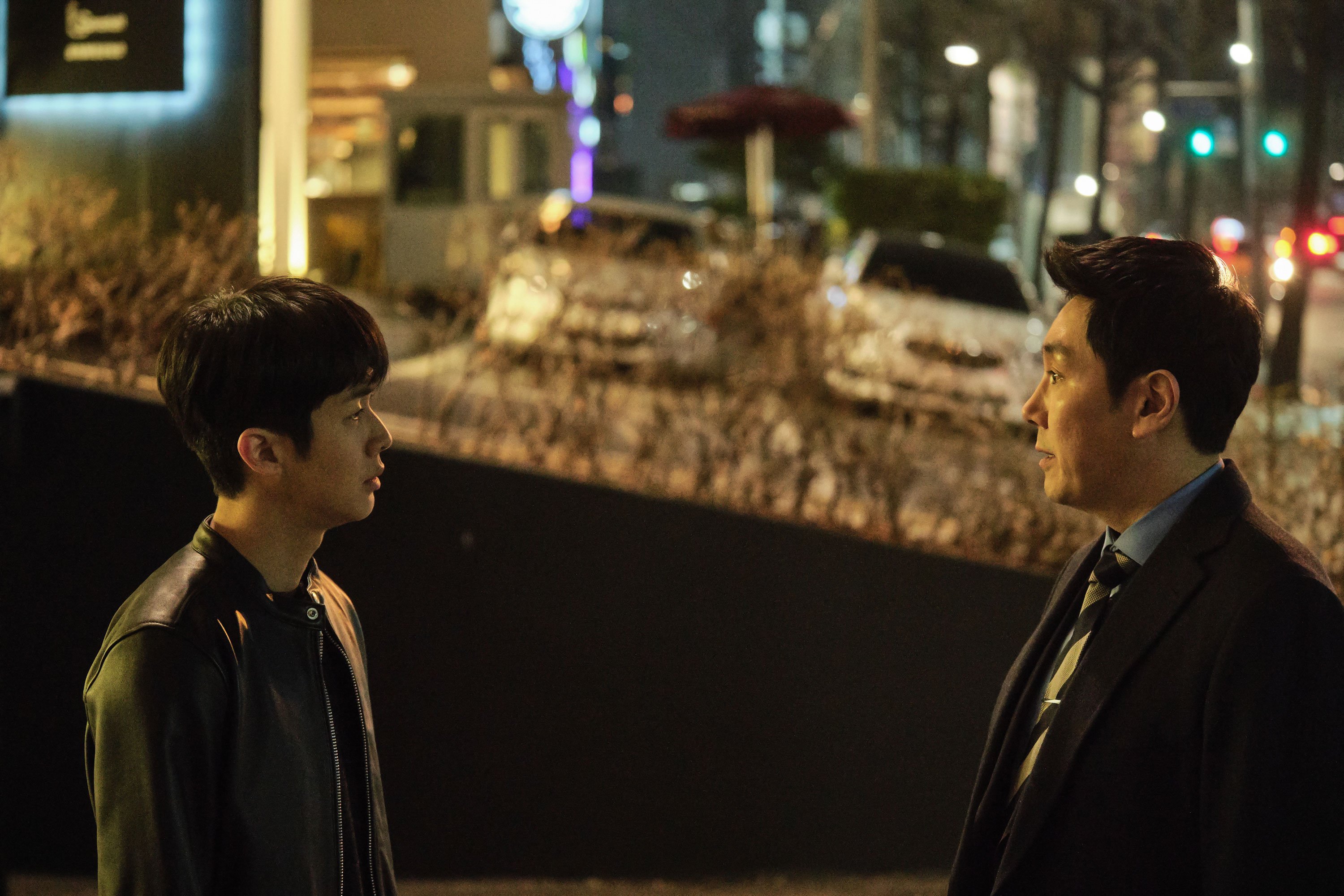 Dựa theo tiểu thuyết Blood of the Policeman do nhà văn Nhật Bản Joh Sasaki chấp bút, Dòng Máu Đặc Cảnh (The Policeman’s Lineage) đã nhanh chóng trở thành tác phẩm điện ảnh ăn khách nhất khi trình chiếu tại quê nhà Hàn Quốc, chấm dứt chuỗi ngày thống trị phòng vé của bom tấn Spider-Man: No Way Home (2021). Quy tụ dàn sao tên tuổi gồm Cho Jin Woong, Choi Woo Shik, Park Hee Soon…, chuyện phim xoay quanh nhân vật Choi Min Jae (Choi Woo Shik), cậu cảnh sát trẻ có niềm tin mãnh liệt vào đạo đức nghề nghiệp. https://www.youtube.com/watch?v=b-nA92Qfi2Q [Trailer Dòng Máu Đặc Cảnh]. Nhờ đức tính này, anh được thanh tra Hwang (Park Hee Soon) bên Bộ Nội Vụ chú ý. Ông cử chàng lính mới sang đơn vị của Park Kang Yoon, điều tra viên cấp cao nổi tiếng nhờ thành tích bắt giữ tội phạm khó ai sánh kịp. Nghi ngờ Park sử dụng nguồn tiền bất chính cho hoạt động phá án, thanh tra Hwang giao Choi Min Jae nhiệm vụ tìm kiếm bằng chứng chứng tỏ gã ta là cớm bẩn. IMG_256 Hình 1: Với bản tính chính trực, chàng cảnh sát Choi được Bộ Nội Vụ giao nhiệm vụ theo dõi điều tra viên Park. Khác hẳn mấy tay cảnh sát xuề xòa, thường xuyên ăn bờ ngủ bụi trên phim Hàn, hai nhân vật chính ở Dòng Máu Đặc Cảnh đảm bảo sẽ làm khán giả thích thú. Vì tính chất công việc chuyên điều tra những kẻ thuộc giới siêu giàu, cặp đôi Park – Choi phải đầu tư cho vẻ ngoài nếu muốn tiếp cận, thu thập thông tin về chúng. Bởi vậy, cả hai luôn xuất hiện trong bộ dạng lịch lãm, lái xe sang cũng như liên tục lui tới các tụ điểm giải trí hào nhoáng. Chưa kể, với phương châm “mọi hoạt động phục vụ việc bắt giữ tội phạm đều hợp pháp”, điều tra viên họ Park chẳng ngại lách luật, sử dụng cách thức không tưởng để tóm gọn nghi can. IMG_257 Hình 2: Phim mang đến hình tượng rất thú vị về người cảnh sát chuyên bắt tội phạm hệ “con nhà giàu”. Giống bao tác phẩm cùng chung chủ đề, đứa con tinh thần do đạo diễn Lee Kyu Man cầm trịch không thiếu yếu tố hành động, đuổi bắt tội phạm gay cấn, hay những kế hoạch đánh án thuyết phục. Tuy vậy, cú lật kèo được tổ biên kịch cài cắm kỹ lưỡng sẽ đưa chúng ta đi từ bất ngờ này sang ngạc nhiên khác, bởi lẽ nó rất mới lạ, liên hệ với rất nhiều nhân vật và góp phần thay đổi hoàn toàn cục diện cuối phim. IMG_258 Hình 3: Tác phẩm cũng cho thấy sự chia rẽ sâu sắc về quan điểm trong nội bộ cảnh sát Hàn Quốc. Không khai thác nỗi sợ bị bại lộ danh tính của các đặc vụ nằm vùng, chính không khí căng thẳng, ngột ngạt trong Dòng Máu Đặc Cảnh là nơi bắt nguồn từ sự dằn vặt, tự vấn bản thân nơi chàng lính mới khi đào bới quá khứ, đời tư cấp trên. Với diễn biến ngày càng gay cấn, bộ phim đặt nam chính lẫn người xem vào không ít tình thế éo le. Đứng giữa lằn ranh thiện ác mong manh, Choi Min Jae buộc phải lựa chọn hoặc đứng về phía thanh tra Hwang – gìn giữ phẩm giá liêm khiết, chính trực dù điều đó có khiến mình để lọt kẻ xấu; hoặc chấp nhận “nhúng chàm” như điều tra viên họ Park nhằm thực thi công lý đến cùng. IMG_259 Hình 4: Tài tử Choi Woo Shik có màn lột xác đáng nhớ ở Dòng Máu Đặc Cảnh. Thoát khỏi hình tượng ngây ngô, vụng về, ngôi sao phim Ký Sinh Trùng Choi Woo Shik có màn lột xác đáng nhớ tại Dòng Máu Đặc Cảnh. Hóa thân thành cậu thanh niên ương ngạnh, anh đã lột tả trọn vẹn tâm trạng day dứt, hoang mang ở một cảnh sát trẻ lần đầu bước vào “vùng xám” của cuộc chiến phòng chống tội phạm, nơi mà lòng tin lẫn lập trường bị thử thách dữ dội. Tiếp tục giữ vững phong độ, “cảnh sát quốc dân” Cho Jin Woong không làm khán giả thất vọng trước vai diễn mới Park Kang Yoon. Mặc dù sở hữu phong cách điều tra “lách luật” chẳng giống ai, nhân vật này vẫn giành được thiện cảm nhờ thái độ lạnh lùng, quyết đoán lúc phá án nhưng lại thân thiện, gần gũi và coi trọng anh em cấp dưới. IMG_260 Hình 5: Nhân vật điều tra viên nửa chính nửa tà Park để lại nhiều ấn tượng cho người xem. Nhìn chung, Dòng Máu Đặc Cảnh đã mang tới làn gió thú vị cho thể loại hình sự, tâm lý tội phạm. Không mặc định bên nào đúng sai, phim để chúng ta tự đưa ra câu trả lời phù hợp cho chính bản thân mình. Nếu ưa thích những tác phẩm chứa đựng nút thắt bất ngờ và đào sâu vào tâm lý nhân vật, đứa con tinh thần của đạo diễn Lee Kyu Man là lựa chọn phù hợp tại thời điểm hiện nay. Dòng Máu Đặc Cảnh (The Policeman’s Lineage) khởi chiếu tại các hệ thống rạp trên toàn quốc từ ngày 25/02/2022. THE POLICEMAN’S LINEAGE - DÒNG MÁU ĐẶC CẢNH - Đạo diễn: Lee Kyu Man - Diễn viên: Cho Jin Woong, Choi Woo Shik, Park Hee Soon... - Thể loại: Tâm lý tội phạm, hành động - Nội dung: Để đổi lấy tập tài liệu mật về người cha đã khuất, chàng cảnh sát trẻ Choi Min Jae mạo hiểm tham gia vào chuyên án hòng “lật tẩy” tay đội trưởng điều tra khét tiếng Park Kang Yoon. Trước những tên tội phạm mưu mô, lòng chính trực của một cảnh sát mới vào nghề hay sự lão luyện, quyết liệt bất chấp ranh giới của đội trưởng Kang sẽ lên tiếng. 